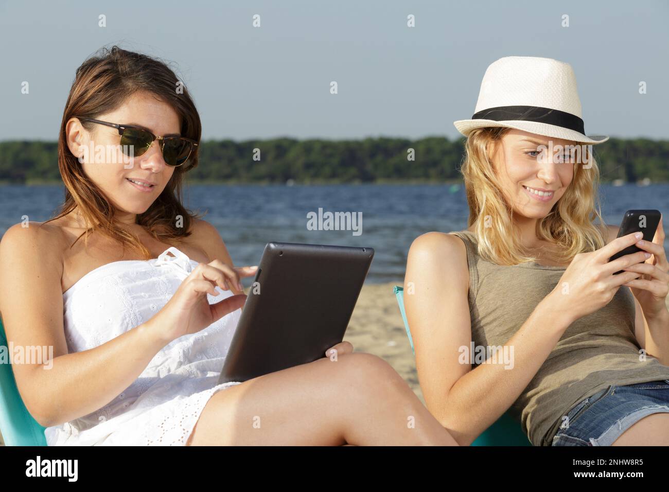 two beautiful women lying on a sunbeds on the beach Stock Photo Alamy