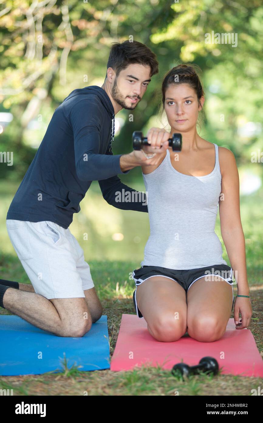 personal trainer adjusting the position of the arm Stock Photo - Alamy