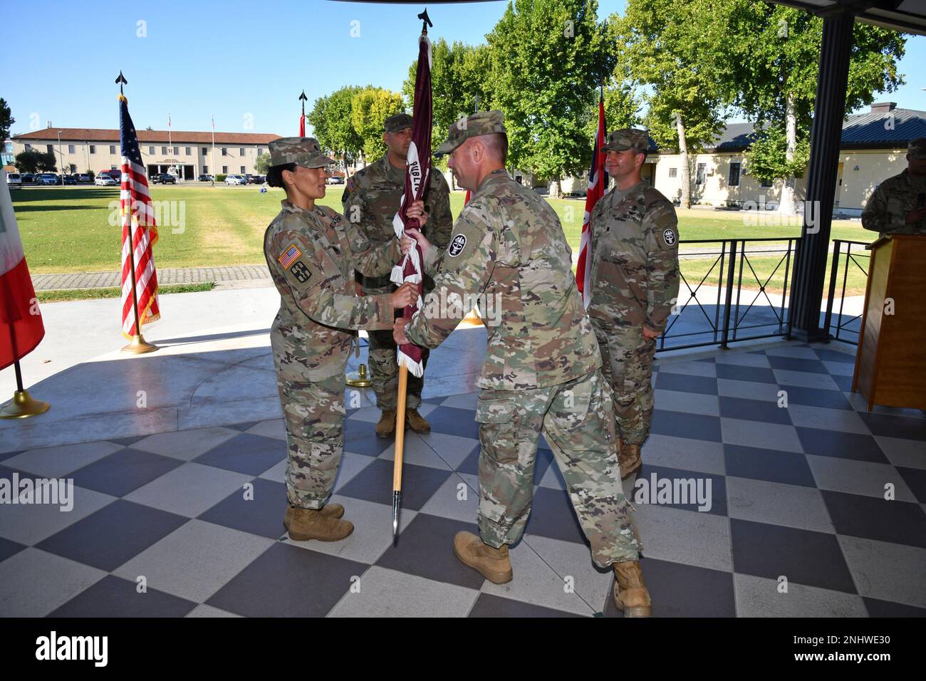U.S. Army Lt. Col. Serena T. Mukai, the incoming Commander, receives the unit colors from Col. Kenneth D. Spicer, the commander of Public Health Command Europe during the Change of Command ceremony at Caserma Ederle in Vicenza, Italy, August 3, 2022. Stock Photo