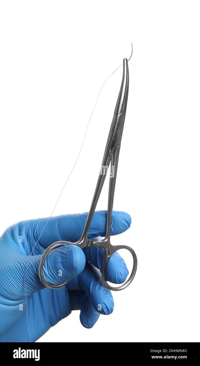 Doctor holding forceps with suture thread on white background, closeup. Medical equipment Stock Photo