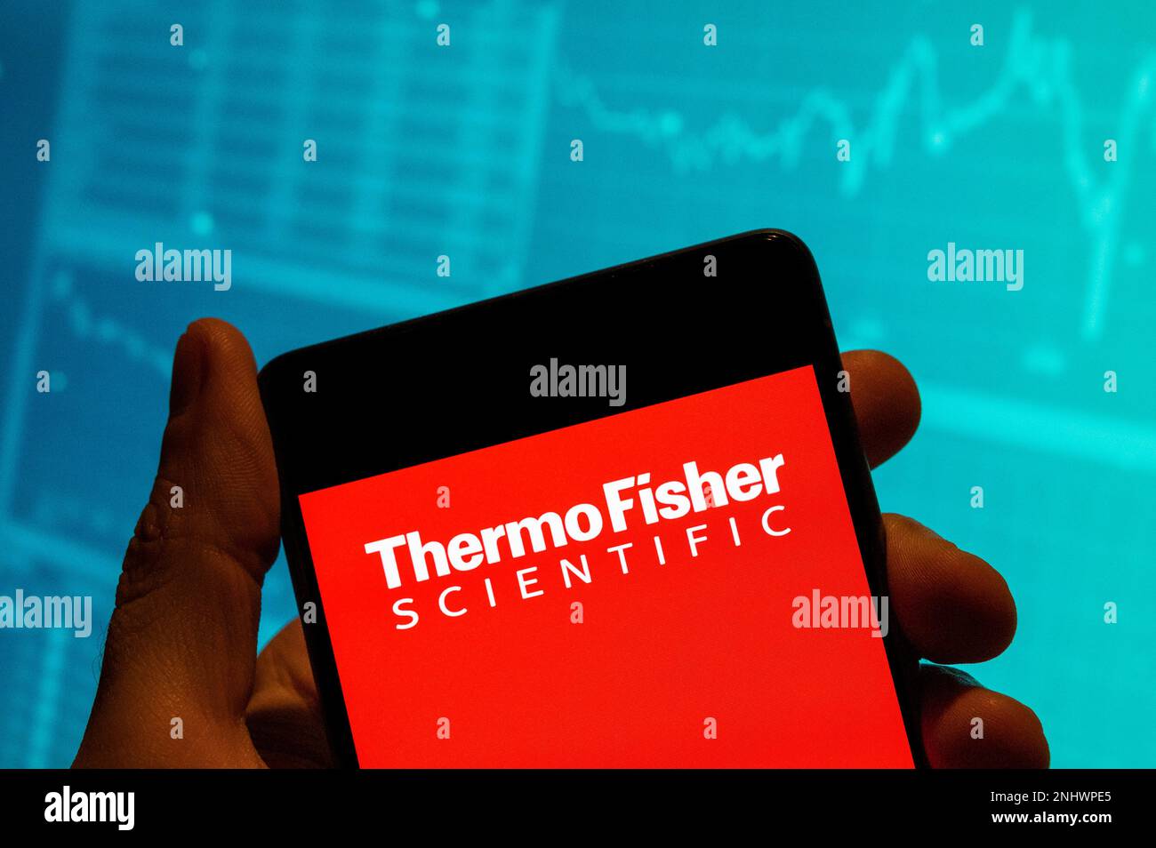 China. 19th Feb, 2023. In this photo illustration, the American supplier of scientific instrumentation, reagents and consumables, and software services company, Thermo Fisher Scientific logo is seen displayed on a smartphone with an economic stock exchange index graph in the background. Credit: SOPA Images Limited/Alamy Live News Stock Photo