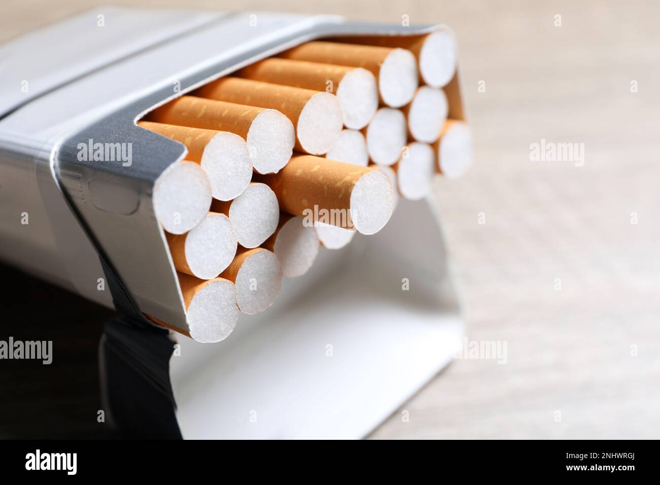 Cigarettes with orange filters in pack on table, closeup Stock Photo Alamy