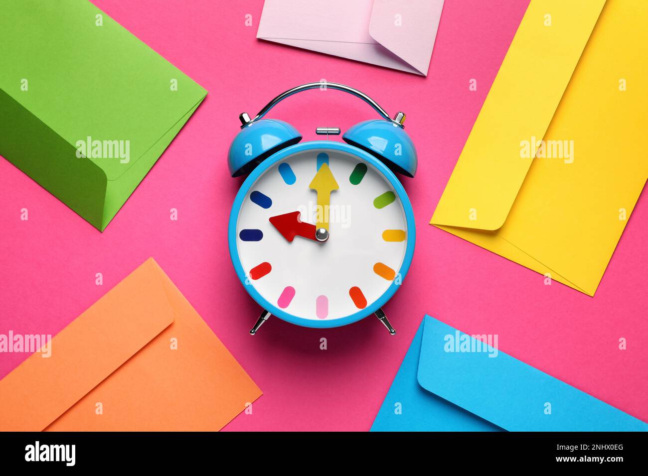 Alarm clock and bright envelopes on pink background, flat lay. Reminder ...