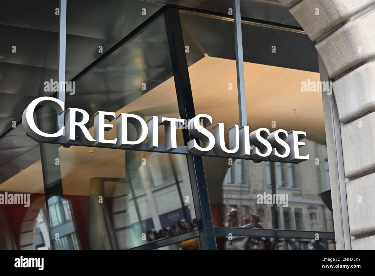 Credit Suisse bank logo created with big white letters is placed on modern building. Stock Photo