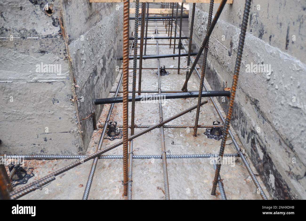 A closeup of a house foundation construction with a wood frame and