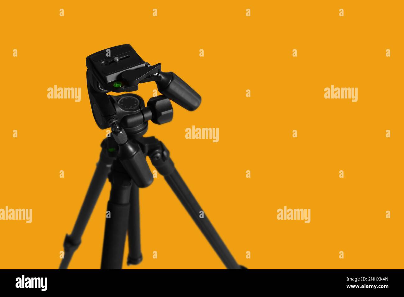 Modern tripod on yellow background. Space for text Stock Photo - Alamy