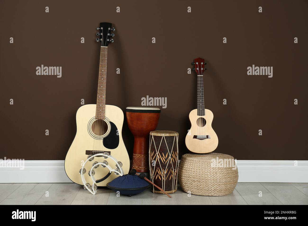 Set of different string and percussion musical instruments near brown