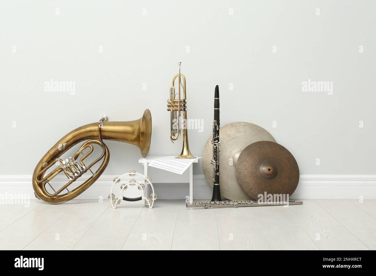 Different percussion and wind musical instruments near white wall indoors Stock Photo Alamy