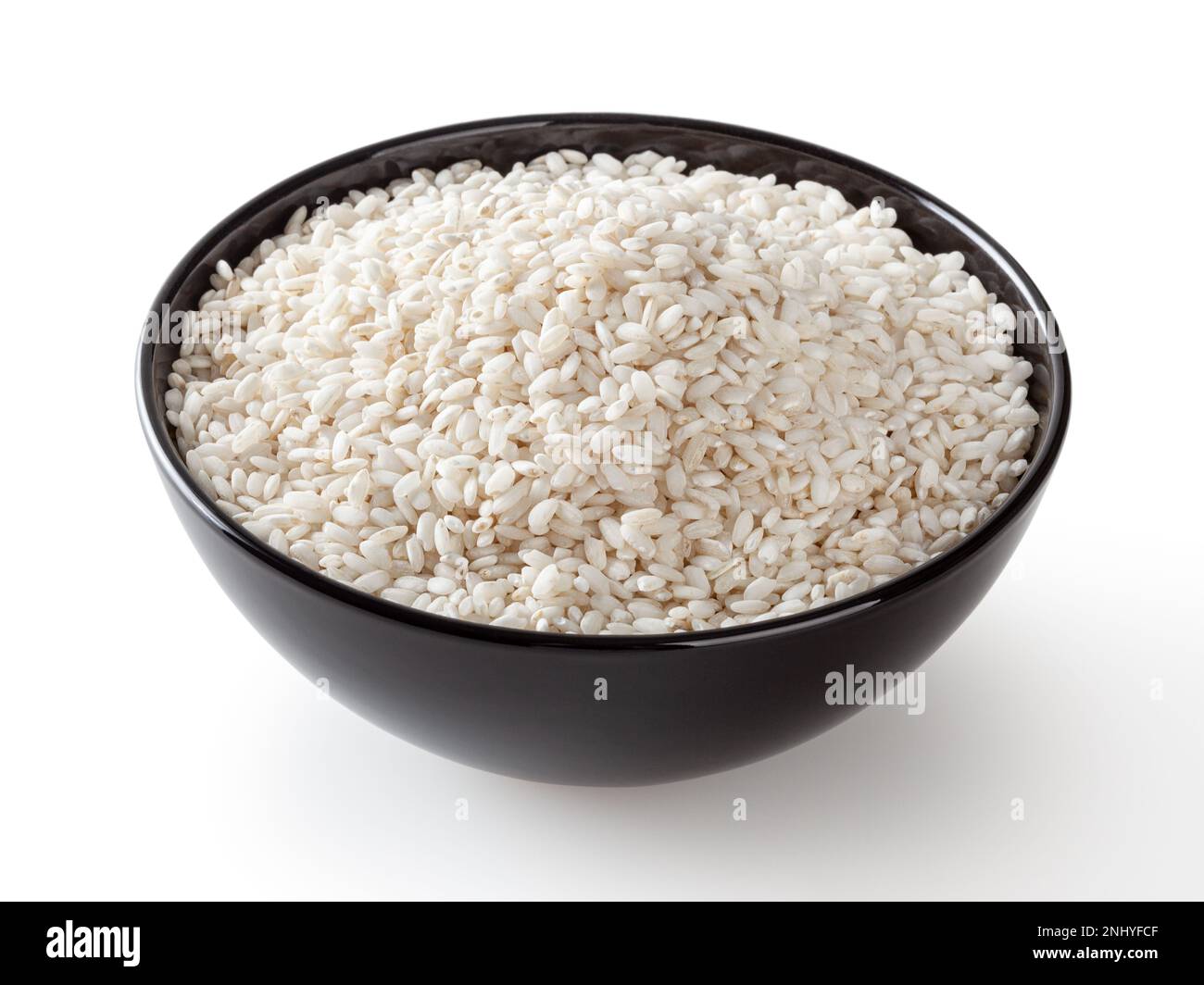 Uncooked arborio rice in black ceramic bowl isolated on white