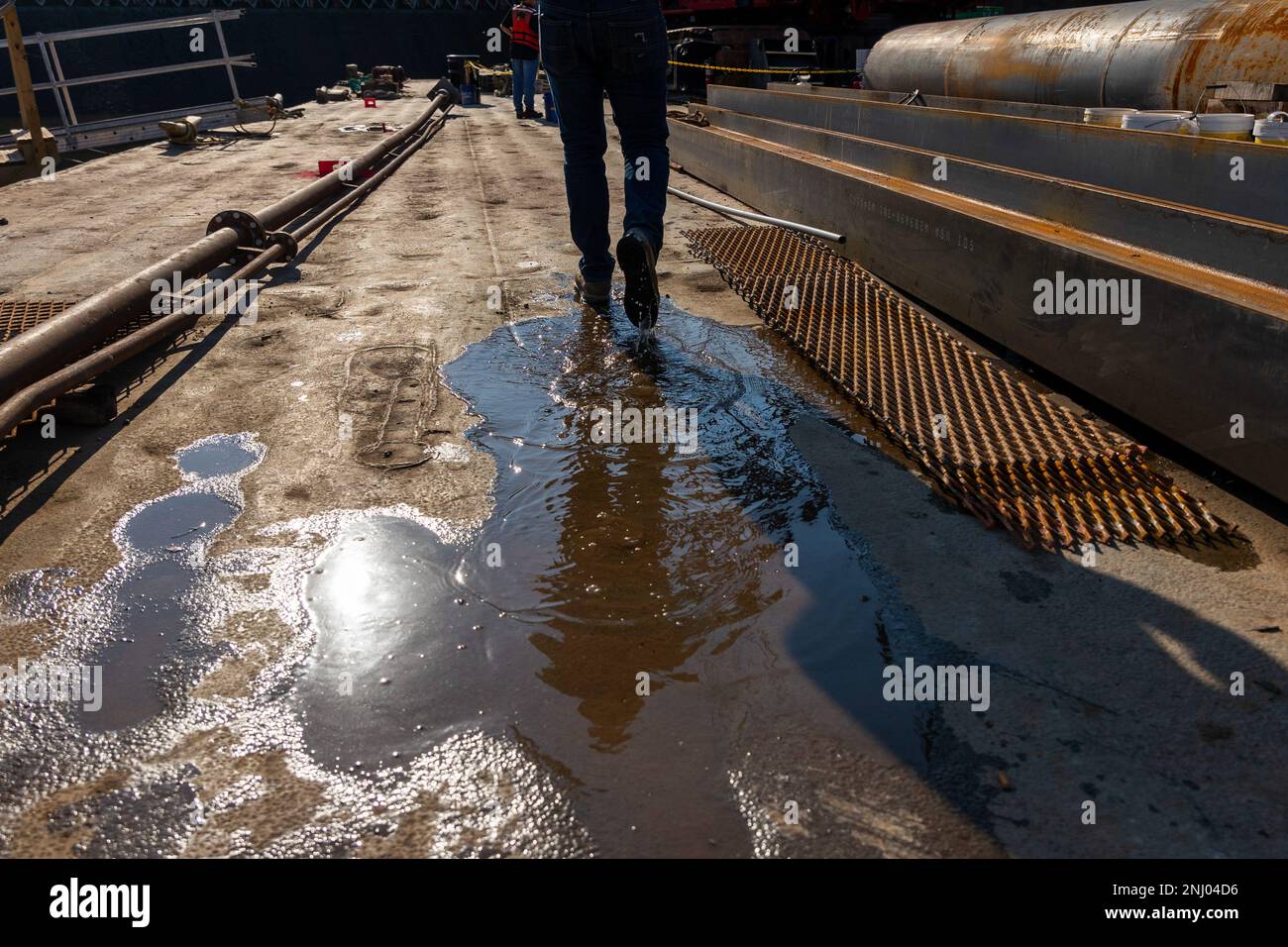 A construction worker walks along a work barge at Montgomery Locks and