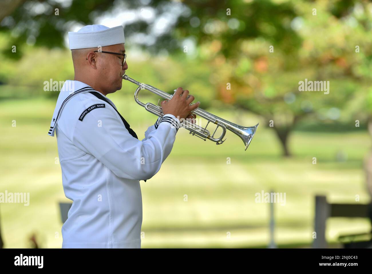 A sailor assigned to U.S. Navy Region Hawaii plays Taps during an internment ceremony for U.S. Navy Water Tender 1st Class Milo E. Phillips at the National Memorial Cemetery of the Pacific, Honolulu, Hawaii, August 4, 2022. Phillips was assigned to the USS Oklahoma, which capsized after sustaining multiple hits from Japanese aircraft and torpedoes, causing the deaths of more than 400 crew members on Dec. 7, 1941, at Ford Island, Pearl Harbor. Stewart was recently identified through DNA analysis by the Defense POW/MIA Accounting Agency (DPAA) forensic laboratory and laid to rest with full milit Stock Photo