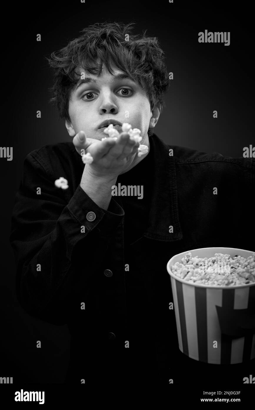 portrait of crazy young man throwing up popcorn Stock Photo