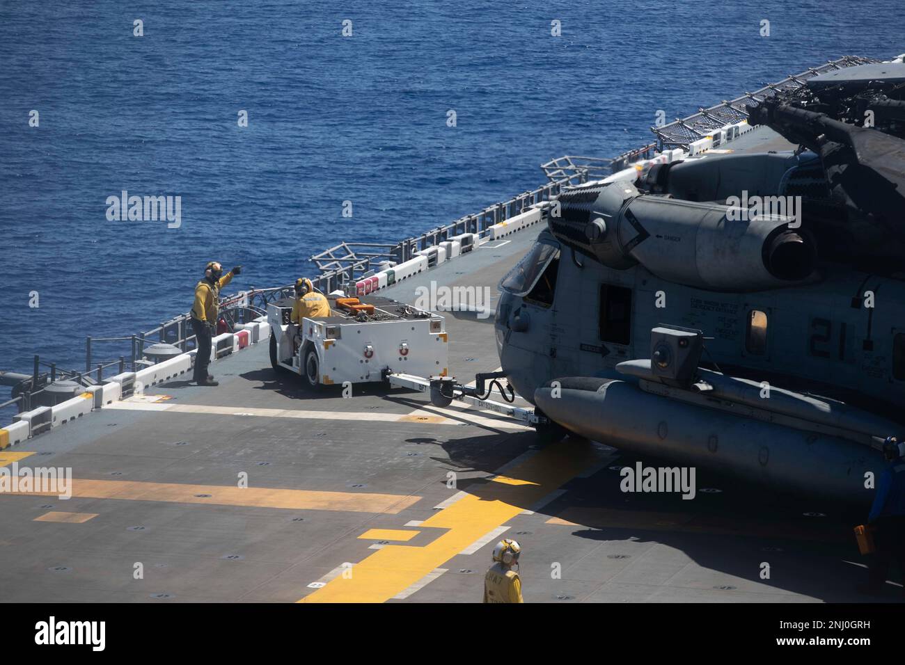 220804-N-VJ326-1025 PACIFIC OCEAN (Aug. 4, 2022) – Sailors use a spotting dolly to move a CH-53 Super Stallion helicopter assigned to Marine Medium Tiltrotor Squadron (VMM) 262 (Reinforced) on the flight deck aboard amphibious assault carrier USS Tripoli (LHA 7), Aug. 4, 2022. Tripoli is operating in the U.S. 7th Fleet area of operations to enhance interoperability with allies and partners and serve as a ready response force to defend peace and maintain stability in the Indo-Pacific region. Stock Photo