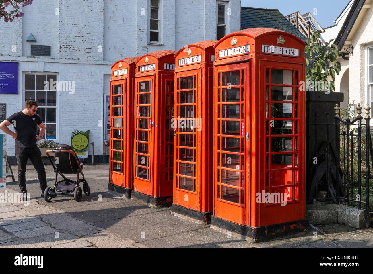 A row of four traditional red telephone boxes in Lemon Street in Truro City centre in Cornwall in the UK in Europe. Stock Photo