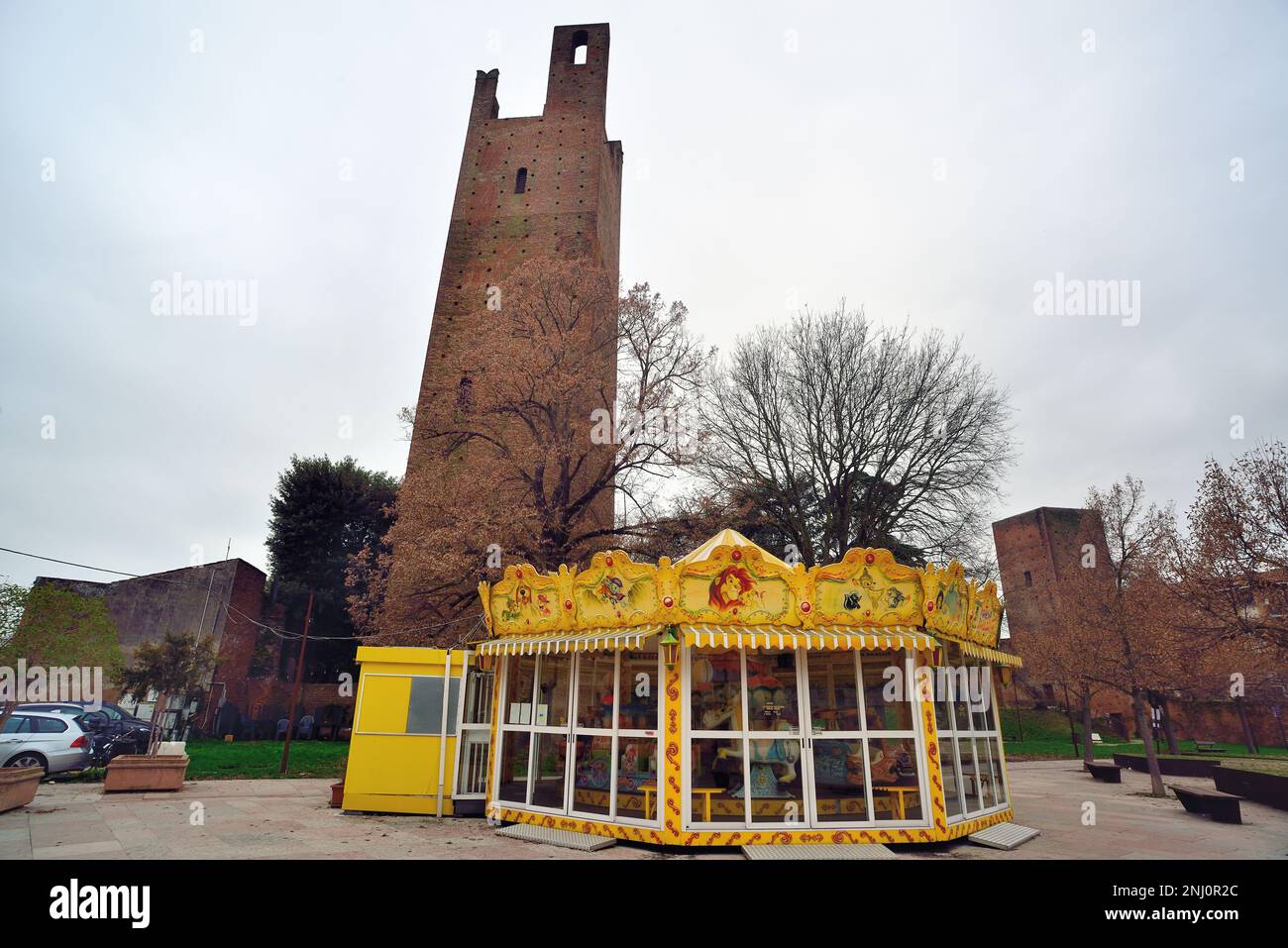 Rovigo, Italy. Donà tower L and Grimani tower or Mozza tower R. the two medieval towers were part of the ancient city walls. In the foreground, a carousel for children. Stock Photo