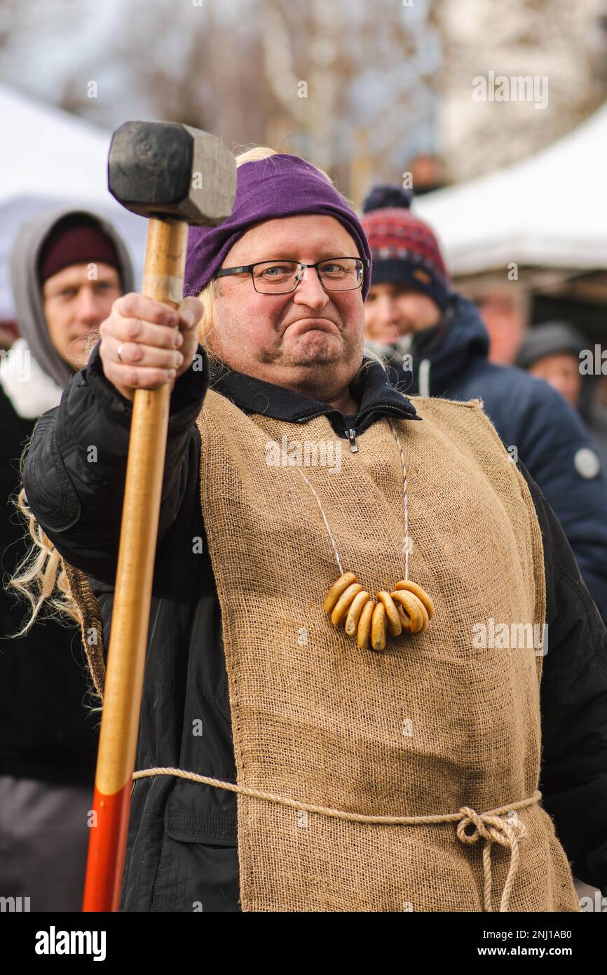 Man with a hammer in a Lithuanian folk festival with traditional Ukrainian and Lithuanian, Eastern European small, crunchy, mildly sweet bread Stock Photo