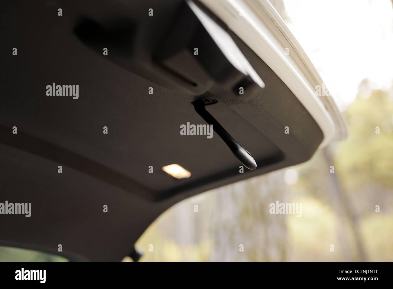 Trunk door handle. Modern white car trunk door opened. Vehicle outdoors