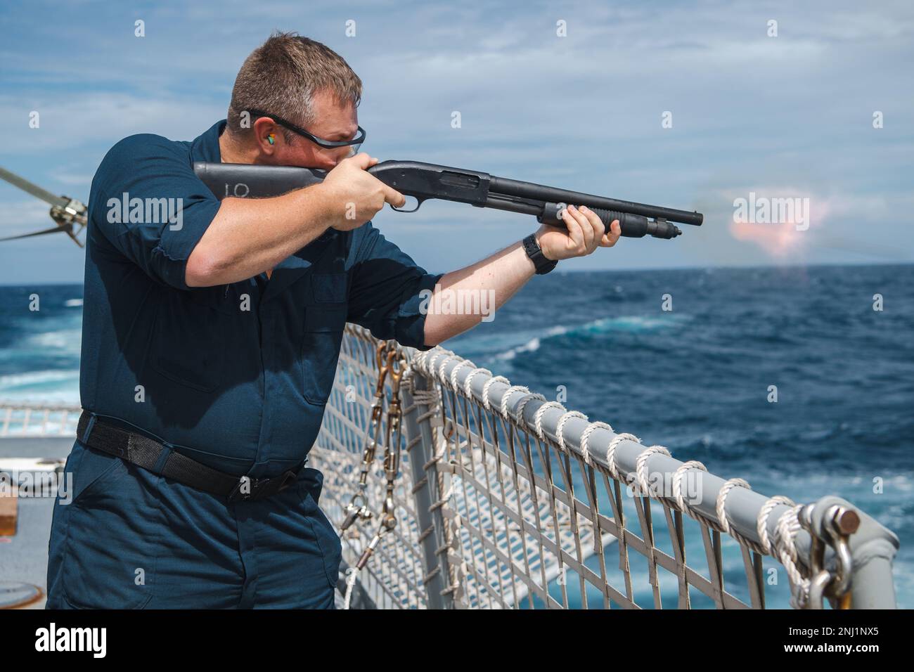 220804-N-TT059-1027  INDIAN OCEAN (August 4, 2022) Master-at-Arms 1st Class Matthew Barksdale fires an M500 shotgun during an at-sea gun range on the flight deck aboard Arleigh Burke-class guided-missile destroyer USS Momsen (DDG 92) in the Indian Ocean, August 4. USS Momsen is assigned to Commander, Task Force 71/Destroyer Squadron (DESRON) 15, the Navy's largest forward-deployed DESRON and the U.S. 7th Fleet's principal surface force. Stock Photo