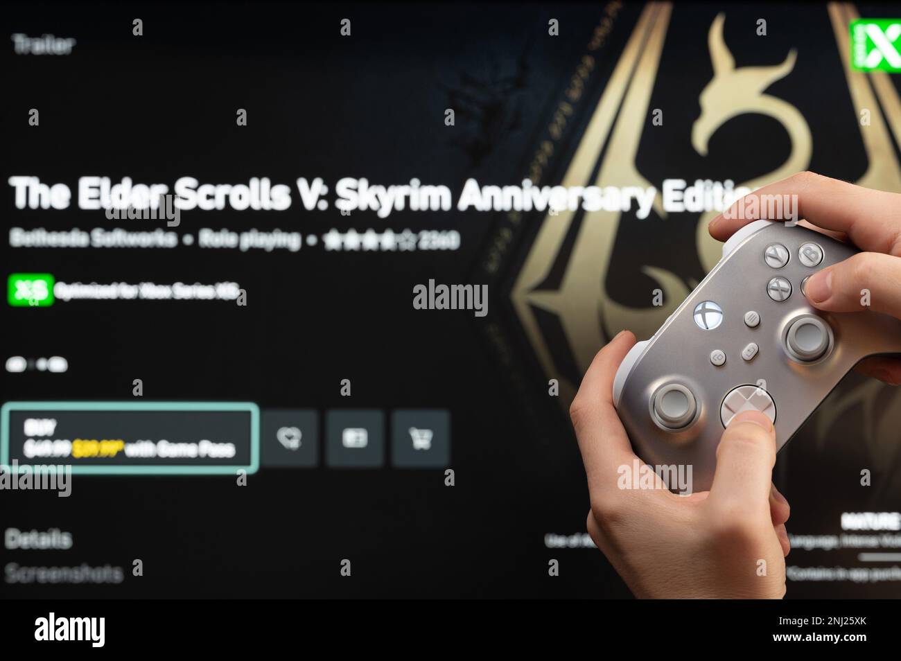 New york, USA - February 20, 2023: Buy new game Elder Scrolls Skyrim in online microsoft xbox store with gamepad controller in hand Stock Photo