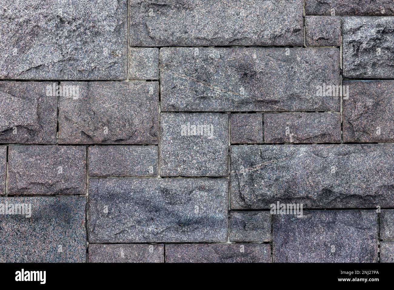 Old gray wall made of rough granite blocks. Close up background photo