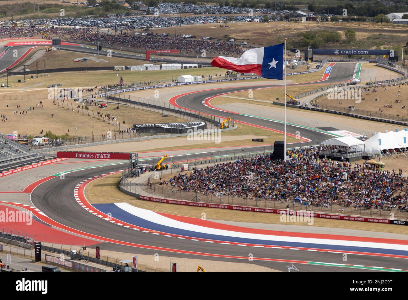 AUSTIN, TX - OCTOBER 23: general admission fans assemble on a lawn below  the Texas flag before the F1 US Grand Prix at Circuit of the Americas on  October 23, 2022 in
