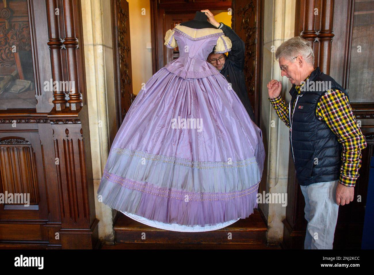 Wernigerode, Germany. 22nd Feb, 2023. Bernd Fraaß (l) and Jürgen Kahmann from Wernigerode Castle Museum carry a tailor's dummy with a ball gown made of silk taffeta sewn around 1860 into the ballroom. The dress is part of the fashion and textile collection Ralf Schmitt which the castle Wernigerode has purchased. The collection consists of about 600 individual objects and represents the dress culture of the wealthy bourgeoisie and the nobility of the 19th century. Credit: Klaus-Dietmar Gabbert/dpa/Alamy Live News Stock Photo