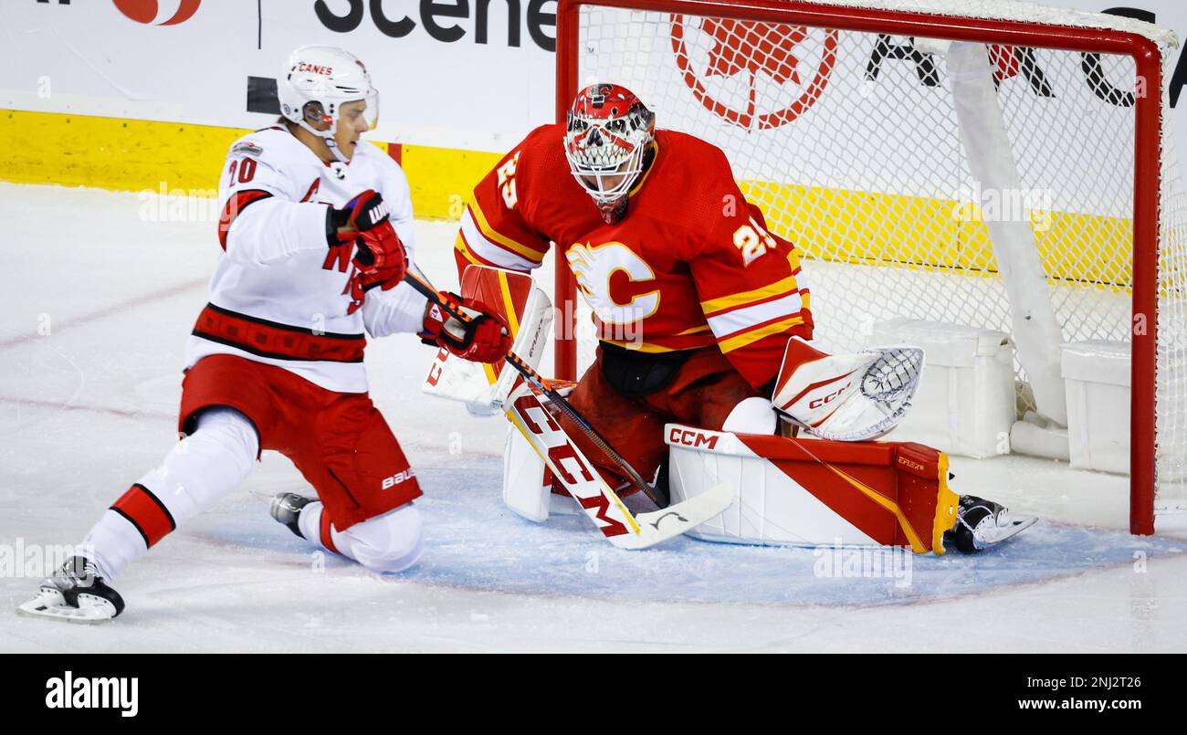 Carolina Hurricanes forward Sebastian Aho, left, scores on Calgary