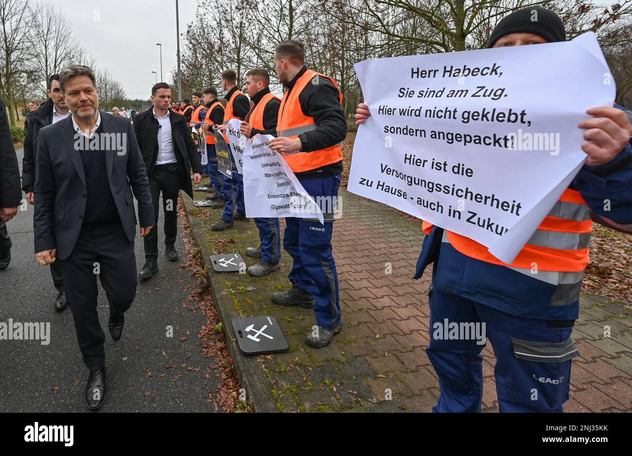 22 February 2023, Brandenburg, Spremberg: Robert Habeck (l. Bündnis 90/Die Grünen), Federal Minister of Economics and Climate Protection, walks past protesting apprentices and employees during a visit to LEAG's Schwarze Pumpe lignite-fired power plant. Robert Habeck visited four sites in Lusatia, in the eastern border region between Brandenburg and Saxony, on the same day to learn about various transformation measures in the opencast mining region. An innovative hydrogen storage power plant is being built at the Schwarze Pumpe industrial park. The power plant is to supply energy generated from Stock Photo