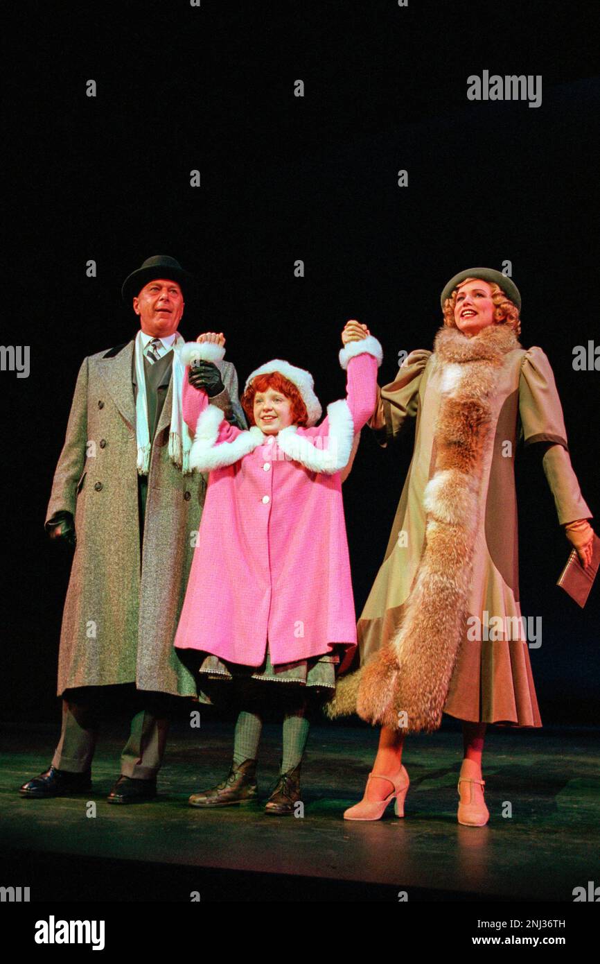 l-r: Kevin Colson (Oliver ‘Daddy’ Warbucks), Charlene Barton (Annie), Kate Normington (Grace Farrell) in ANNIE at the Victoria Palace Theatre, London SW1  01/10/1998  book: Thomas Meehan  music: Charles Strouse  lyrics: Martin Charnin  set design: Kenneth Foy  costumes: Theoni V Aldredge  lighting: Ken Billington  original choreography: Peter Gennaro  director: Martin Charnin Stock Photo