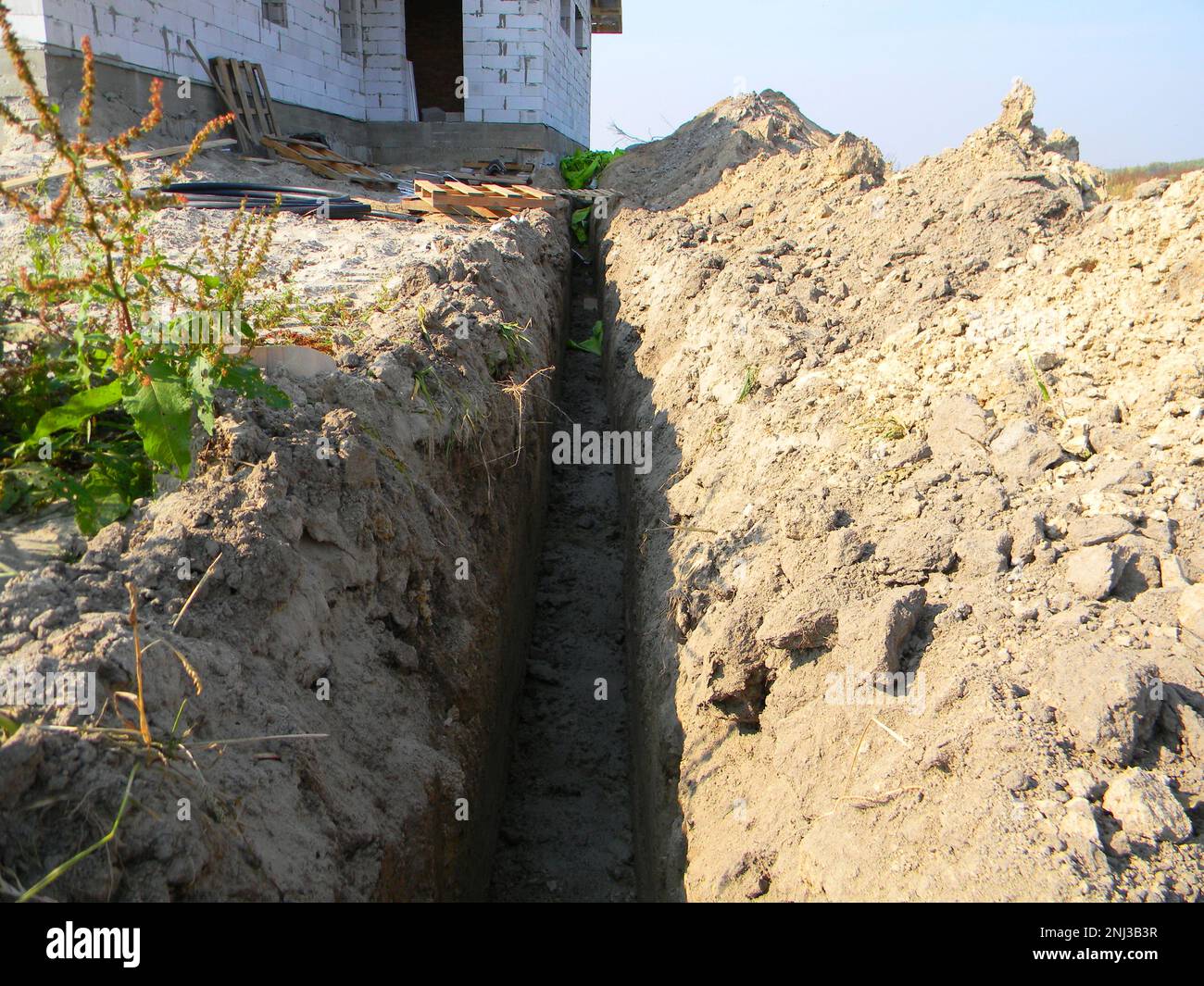 Digging a ground trench for house sewer pipes. Earthworks, digging