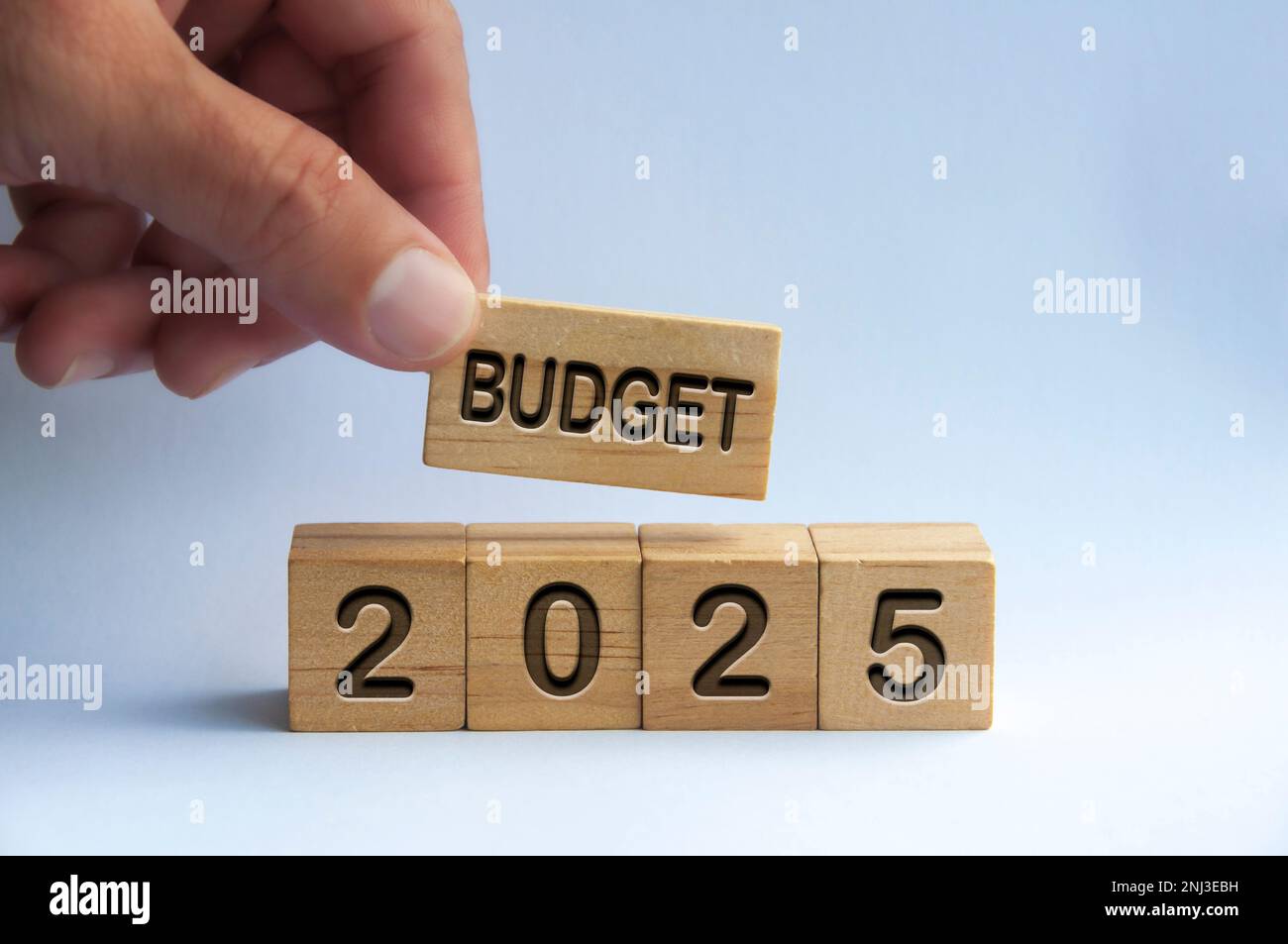 Hand holding wooden block with text Budget 2025 with blurred nature
