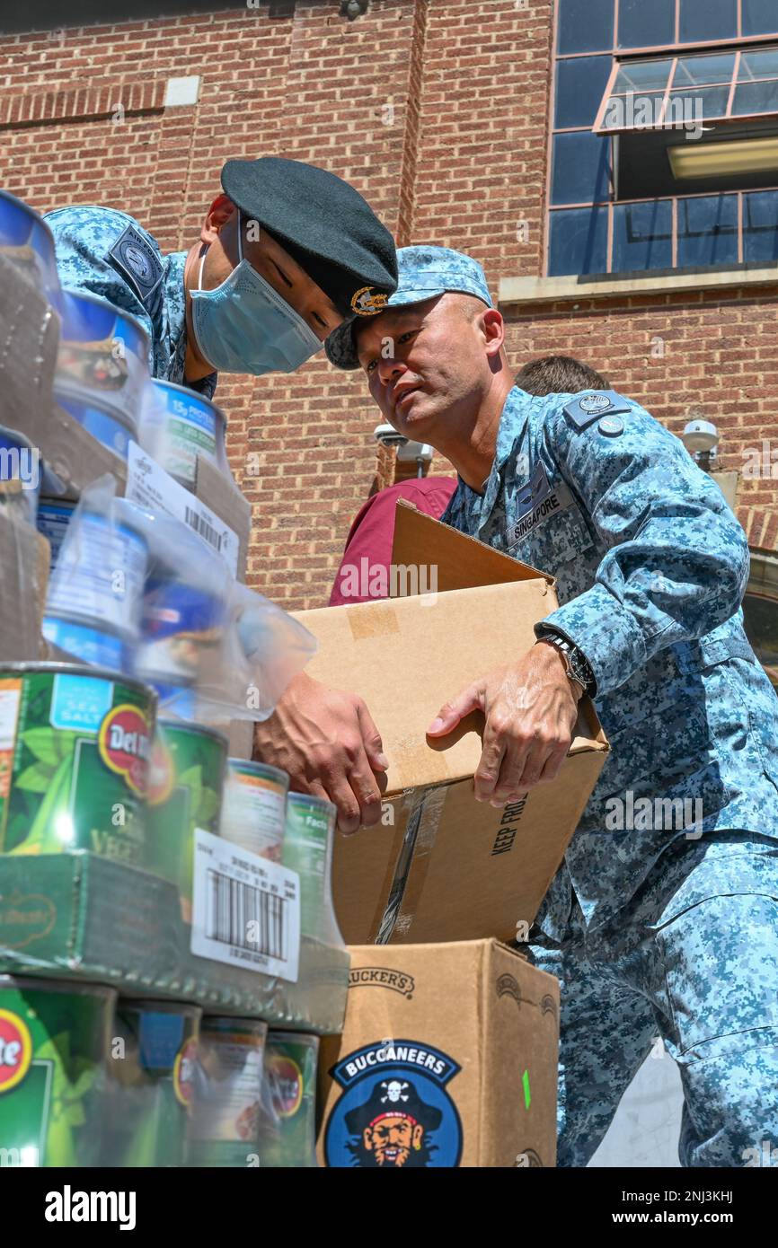 Military Expert 2-1 Tan Ping Siong and ME4-2 and Tan Eit Haw, 428th Fighter Squadron from the Republic of Singapore Air Force, transport boxes of food donations at Bennett Mountain High school on August 4, 2022, Mountain Home, Idaho. The Squadron organized a food drive and partnered with Bennet Mountain High School for distribution to the community. Stock Photo