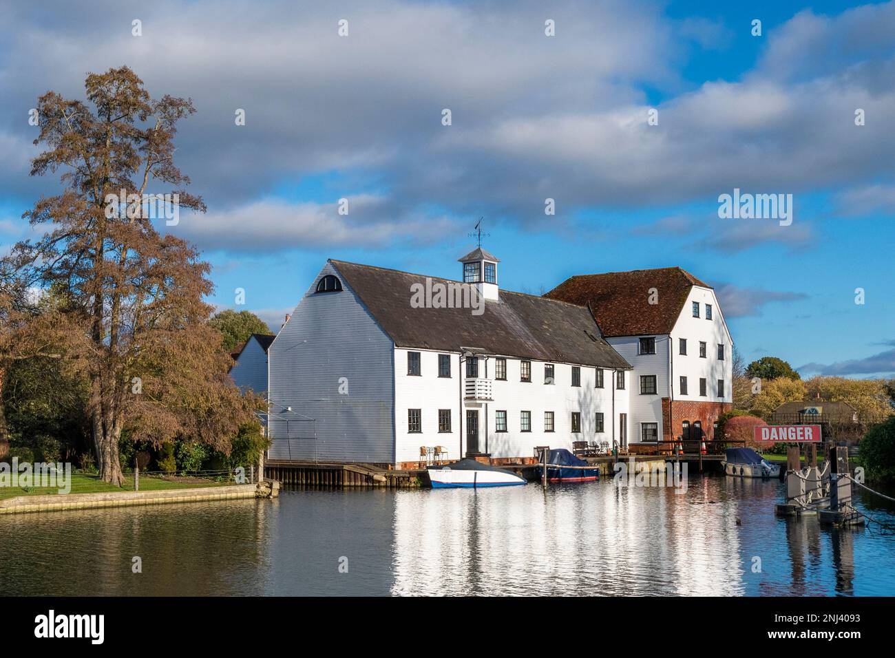Riverside houses overlooking Hambledon weir and  lock ,upper thames on a sunny day with the Thames in flood after rain storms. nr henley-on-thames Stock Photo