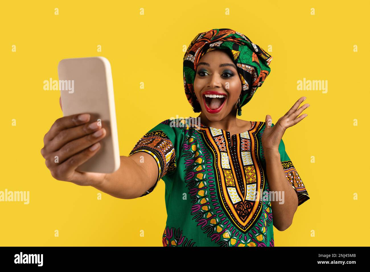 Emotional african woman looking at smartphone screen and gesturing ...