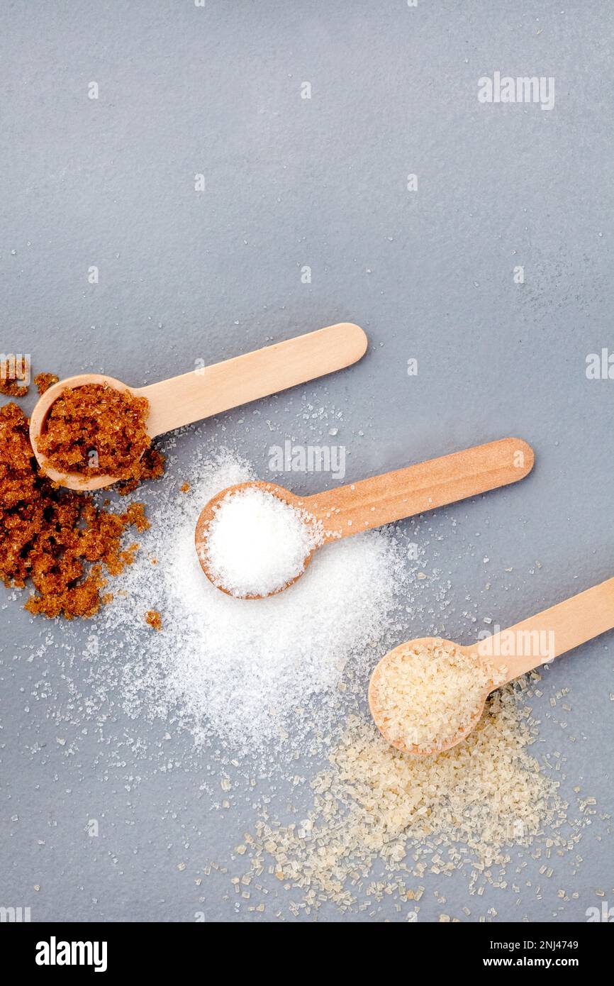 Scoops of different sugars on mottled gray surface Stock Photo Alamy