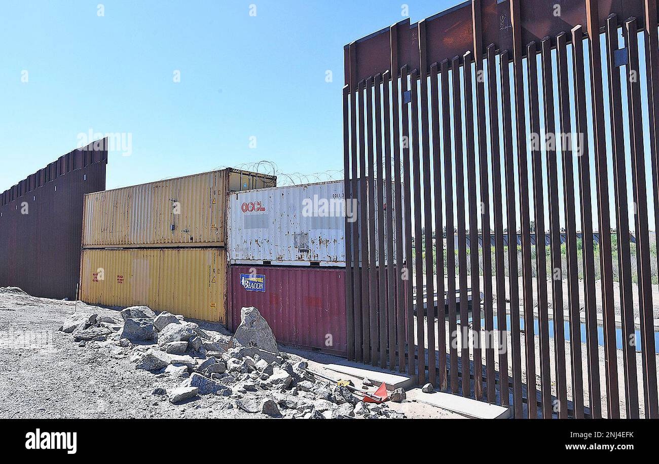 Shipping containers stacked two high fill a gap in the 30foothigh bollard border fence near