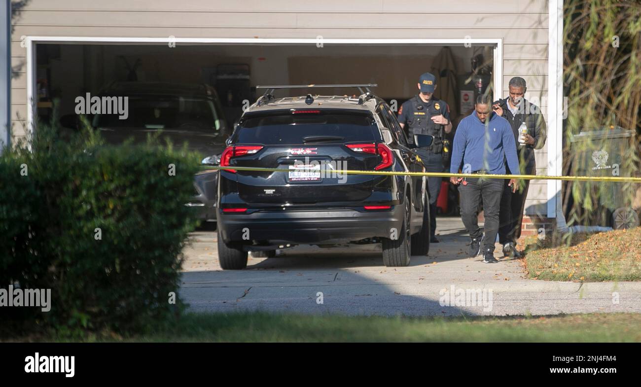 Police escort unidentified men out of the garage on Friday, Oct. 14, 2022  in Raleigh, N.C. as they continue to investigate the shootings on Thursday  night on the greenway nearby. Police say