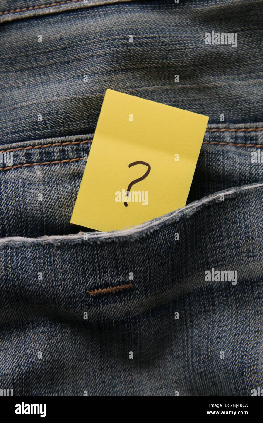 A question mark on a paper tag in a jeans pocket. Question mark on