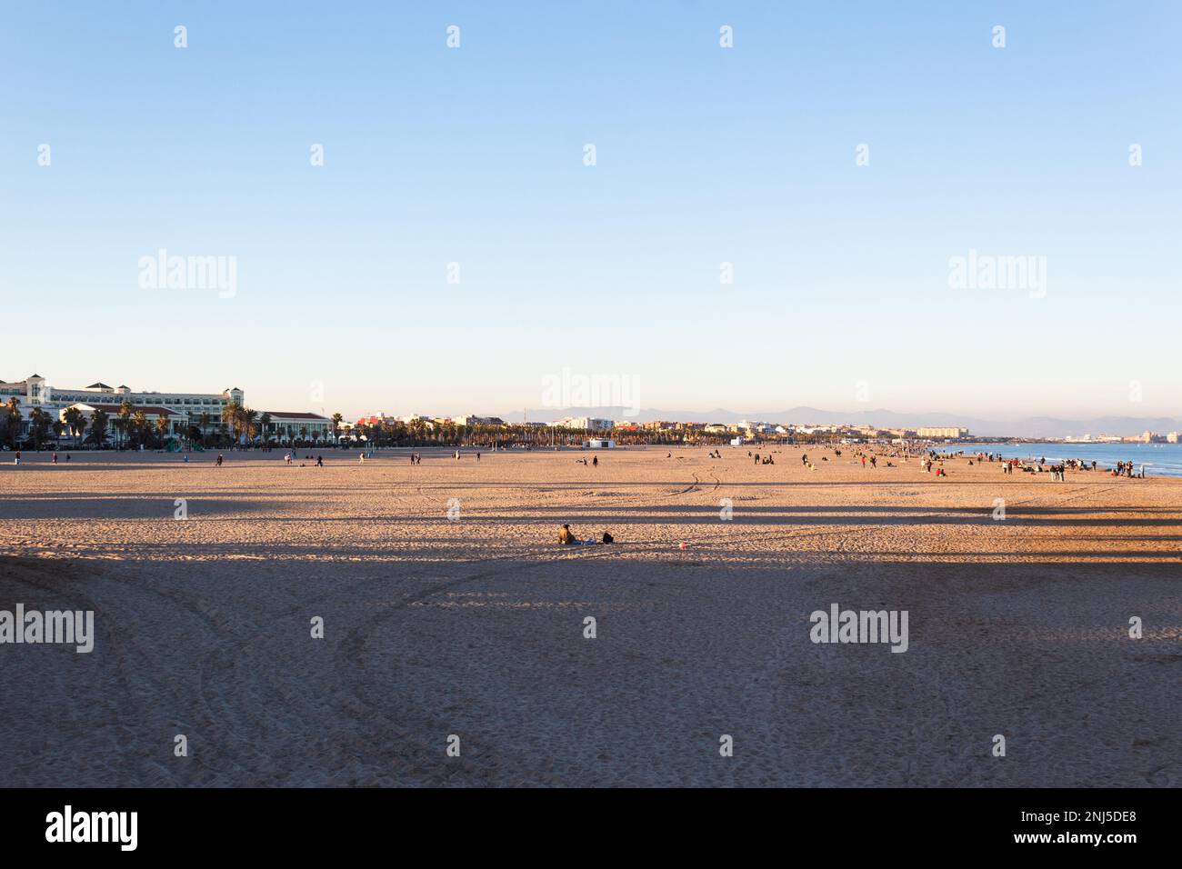 People enjoying a sunny and quiet afternoon on Malvarrosa Beach. Valencia - Spain Stock Photo