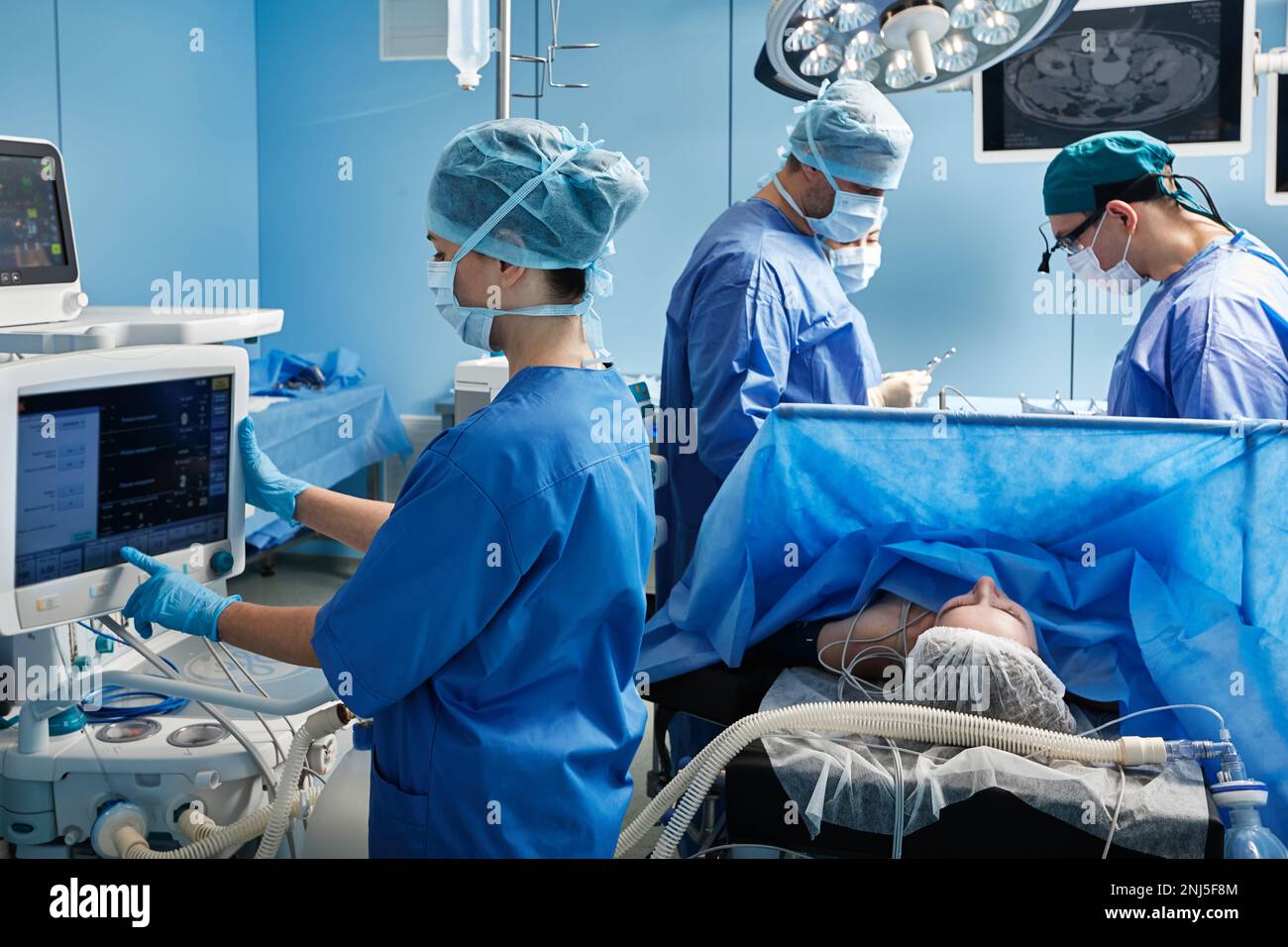 hospital operating theatre with medical team wearing personal protective equipment while surgical operation. Teamwork in surgical department Stock Photo