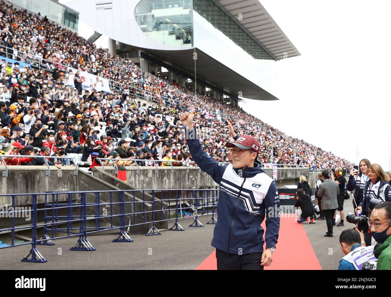 yuki-tsunoda-of-japan-waves-his-hands-during-a-parade-of-formula-1