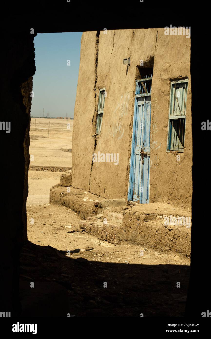 view of house wall and blue door. shadow frames perspective. abandoned village near luxor egypt Stock Photo