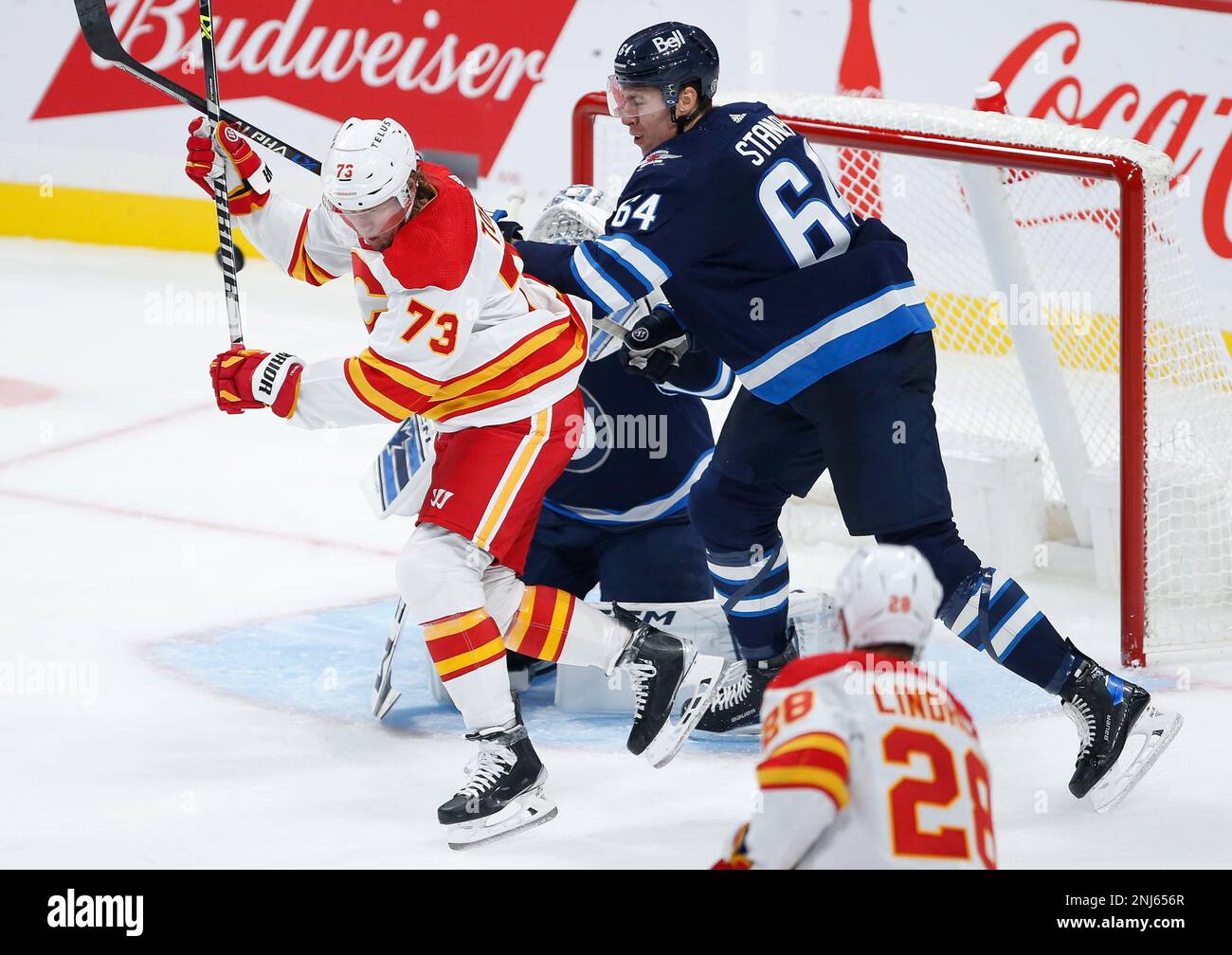 Calgary Flames Tyler Toffoli (73) attempts to deflect the puck past Winnipeg Jets goaltender David Rittich as Logan Stanley defends during the third period of a preseason NHL hockey game in Winnipeg,