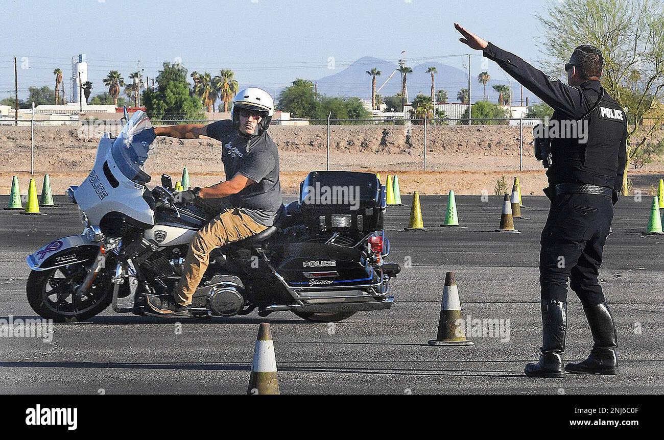 Yuma Police Department Motorcycle Sgt. Johnny Vidrio, right, offers
