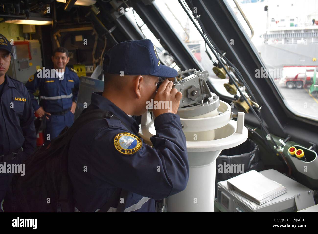 220805-N-N3764-1007  MANTA, Ecuador - (Aug. 5, 2022) -- An Ecuadorian navy sailor looks through a telescopic alidade while taking a tour aboard the Freedom-variant littoral combat ship USS Billings (LCS 15) in Manta, Ecuador, Aug. 5, 2022. Billings is deployed to the U.S. 4th Fleet area of operations to support Joint Interagency Task Force South’s mission, which includes counter-illicit drug trafficking missions in the Caribbean and Eastern Pacific. Stock Photo