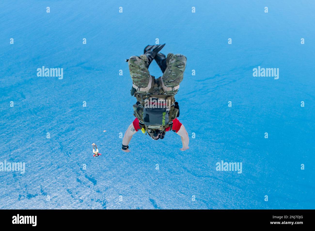 A 31st Rescue Squadron pararescueman jumps out after a raft and his teammates from the back of a 1st Special Operations Squadron MC-130J Commando II over the Pacific Ocean, Aug. 5, 2022. During the training, PJs parachuted to a location in the ocean and then boarded a raft that had been dropped earlier, proceeding to navigate back to shore. Stock Photo