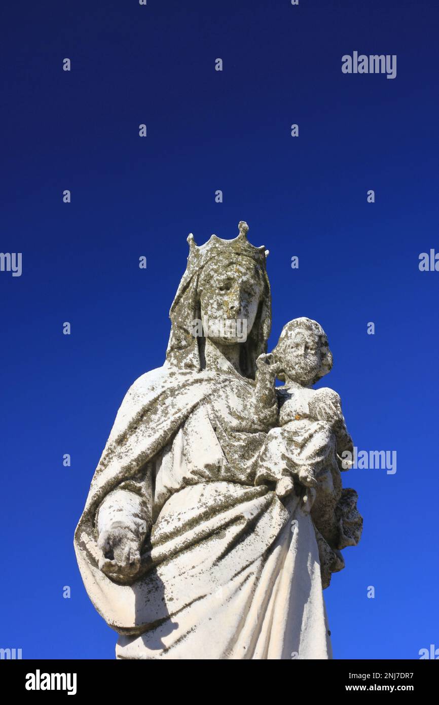 A statue of a crowned Virgin Mary holding the baby Jesus in her arms ...