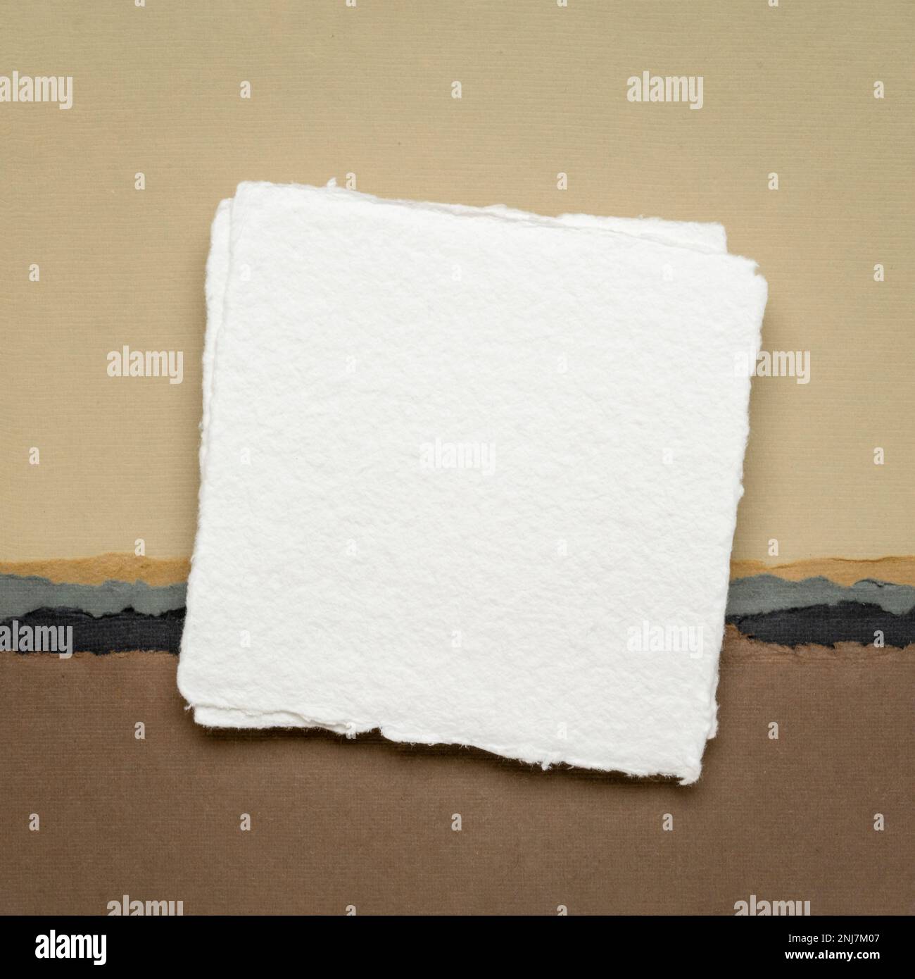 small square sheet of blank white Khadi paper against abstract in
