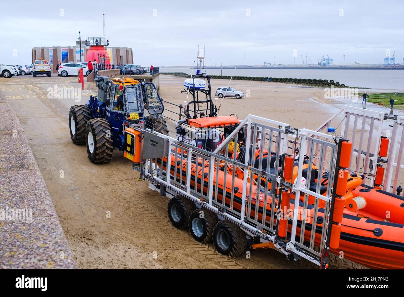 New Brighton life boat crew recovering the boat back up the beach with tractor towing the rib on a trailer after completing a rescue out to sea Stock Photo
