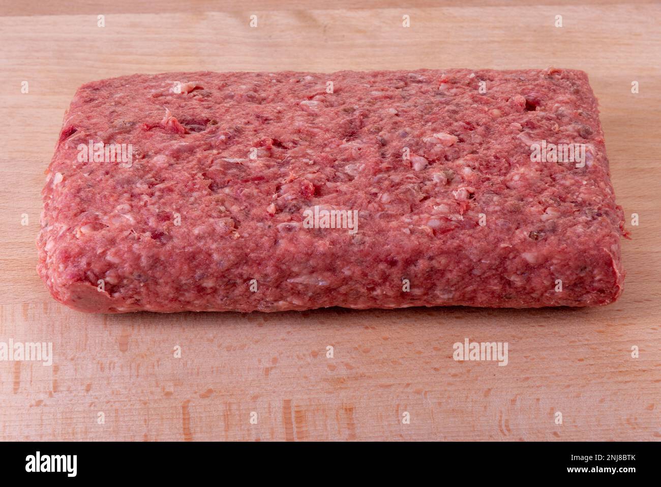 Rolata of raw minced meat on a wooden cutting board ideal for stuffing Stock Photo